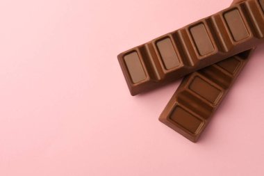 Pembe arka planda nefis çikolatalar, düz bir yatak. Metin için boşluk