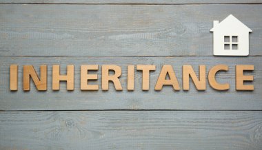 Gri ahşap arka planda harflerle ve ev modeliyle yapılmış bir kelime.