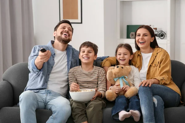 家庭でテレビを見て幸せな家族 お父さん遠隔操作でチャンネルを変える — ストック写真