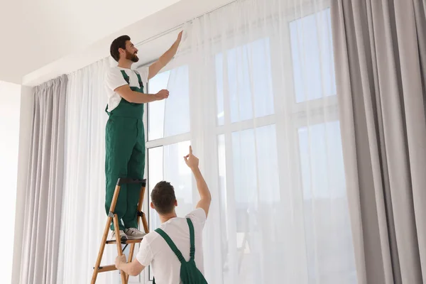 均一な吊り窓カーテン内の労働者 低角度ビュー — ストック写真