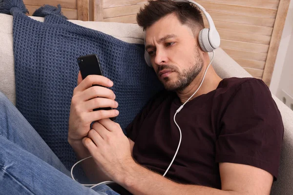 Hombre Molesto Escuchando Música Través Auriculares Sofá Casa Concepto Soledad —  Fotos de Stock