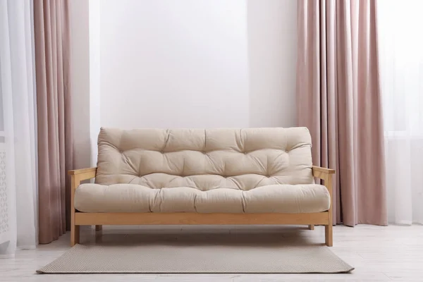Comfortable sofa with rug in cozy light room. Interior design