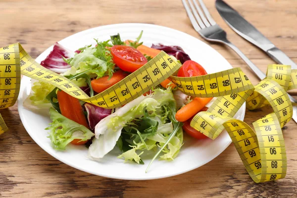新鮮な野菜サラダと木製のテーブルの上にテープを測定プレート 健康的な食事のコンセプト — ストック写真