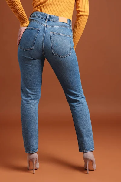 Mulher Jeans Elegantes Fundo Marrom Close — Fotografia de Stock