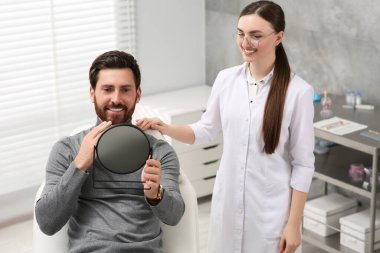 Adam yeni diş implantlarına bakıyor.