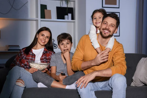 Happy family watching TV at home in evening