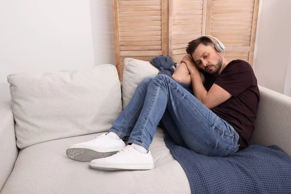 Hombre Molesto Escuchando Música Través Auriculares Sofá Casa Concepto Soledad —  Fotos de Stock