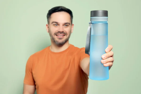 Glücklicher Mann Zeigt Transparente Plastikflasche Wasser Vor Hellgrünem Hintergrund Fokus — Stockfoto