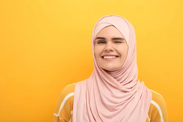头戴头巾的穆斯林妇女在橙色背景下眨眼 文字空间 — 图库照片