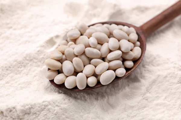 小麦粉に白い腎臓豆と木製のスプーン クローズアップ — ストック写真