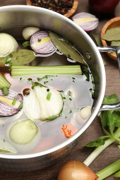 Stock image Pot and different ingredients for cooking tasty bouillon on wooden table, above view