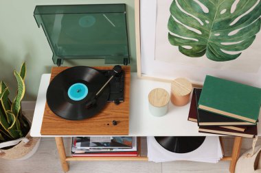 Odada vinil kayıt konsolu olan şık bir pikap.