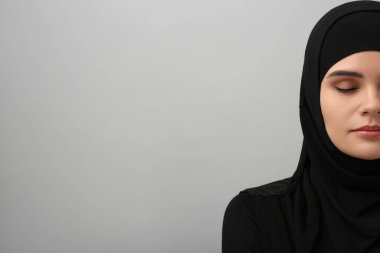 Açık gri arkaplanda tesettürlü Müslüman kadın, metin için boşluk