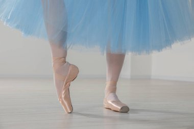 Sivri ayakkabılı balerin ve açık mavi etekli içeride dans eden, yakın plan.