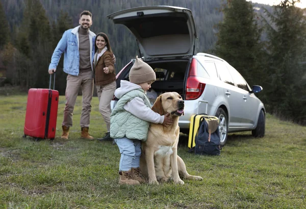 かわいい女の子と山の中で車の近くに彼女の両親 ペットと家族旅行 — ストック写真
