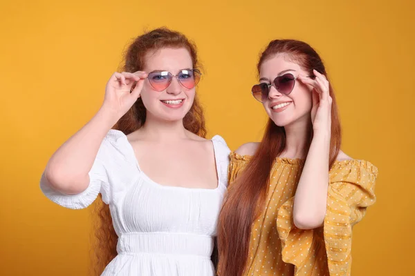 Retrato Belas Irmãs Ruivas Com Óculos Sol Fundo Laranja — Fotografia de Stock