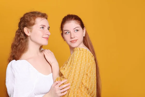 Turuncu Arka Planda Güzel Kızıl Saçlı Kız Kardeşlerin Portresi Metin — Stok fotoğraf