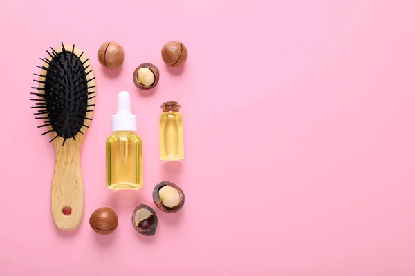 stock image Delicious organic Macadamia nuts, natural oil and brush on pink background, flat lay. Space for text