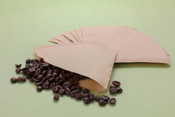 Papierkaffeefilter Und Verstreute Bohnen Auf Hellem Olivenhintergrund — Stockfoto