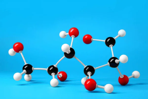 Molecule of glucose on light blue background. Chemical model
