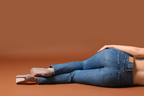 茶色の背景にスタイリッシュなジーンズの女性 クローズアップ テキストのスペース — ストック写真
