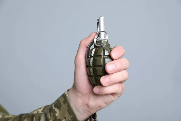 ライトグレーの背景に手榴弾を保持兵士 クローズアップ — ストック写真