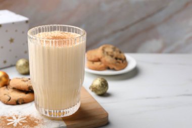 Beyaz masada tarçınlı bir bardak nefis eggnog, mesaj için yer var.