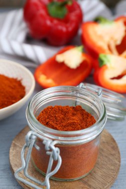 Aromatik kırmızı biber tozu ve gri ahşap masada taze dolma biber.