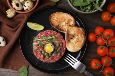 Lezzetli biftekli tart, bıldırcın yumurtası ve ahşap masada diğer eşliğinde servis edilir.