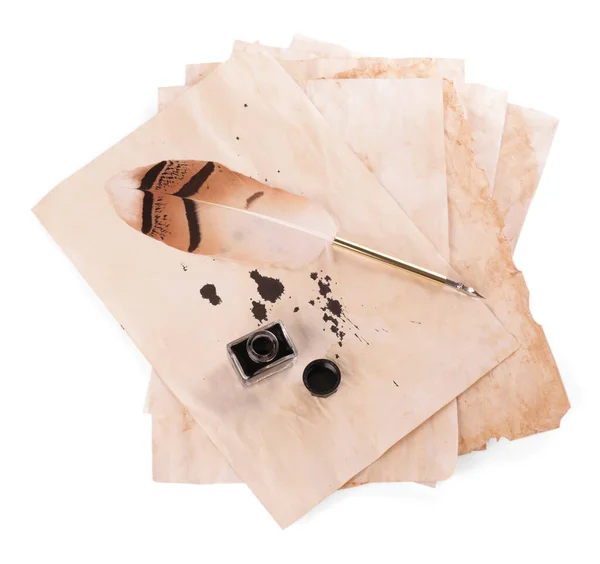 Parchment with stains of ink, feather pen and inkwell on white background, top view
