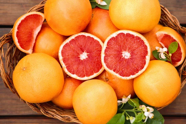 Weidenkorb Mit Frischen Grapefruits Und Grünen Blättern Auf Holztisch Draufsicht — Stockfoto