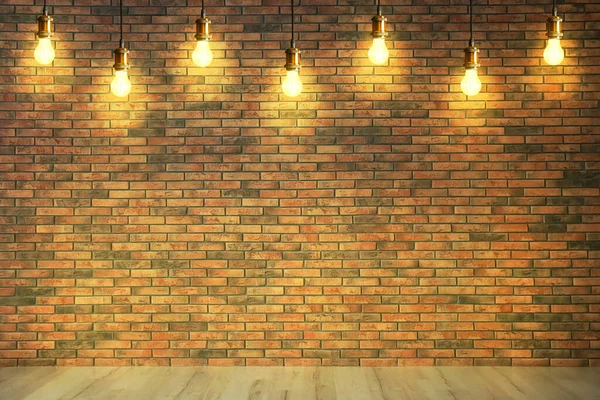 Many pendant lamps in room with brick wall