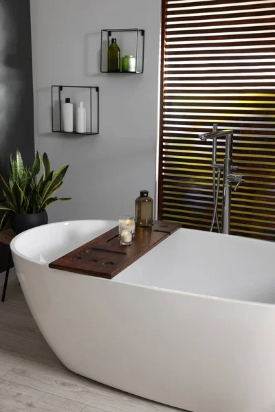 木制浴盆内装有陶瓷浴缸 蜡烛和护肤用品的风格别致的浴室 — 图库照片