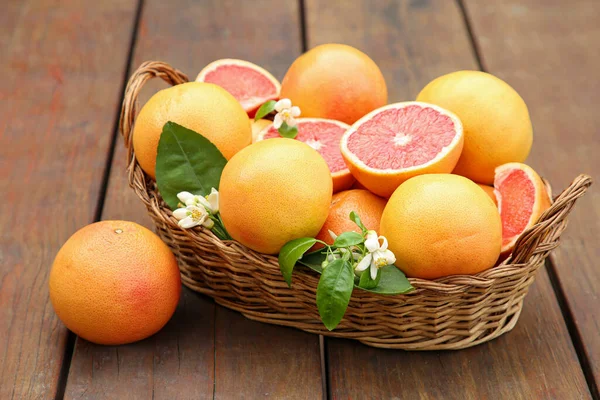 Weidenkorb Mit Frischen Grapefruits Und Grünen Blättern Auf Holztisch — Stockfoto