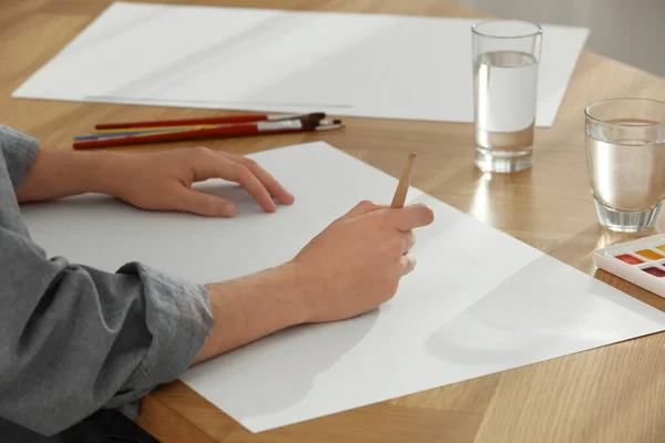 木製のテーブルの上の空白の紙に水彩で男の絵 クローズアップ — ストック写真
