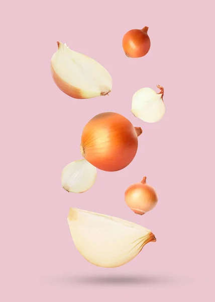Cut Whole Onions Falling Pastel Pink Background — Stock Photo, Image