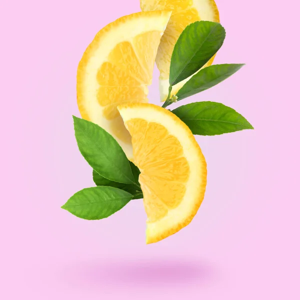 Вирізати Свіжий Лимон Зеленим Листям Падає Рожевий Фон — стокове фото