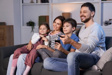 Mutlu aile akşamları evde televizyon izliyor. Babam uzaktan kumandayla kanal değiştiriyor.