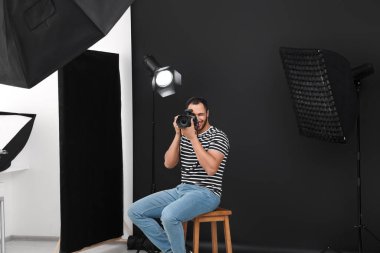 Modern fotoğraf stüdyosunda fotoğraf çeken genç profesyonel fotoğrafçı.