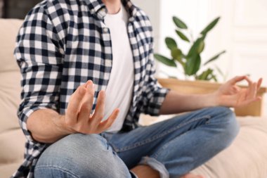 Adam içeride meditasyon yapıyor, yakın plan. Ahenk ve zen