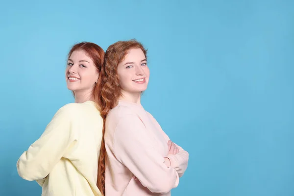 Açık Mavi Arka Planda Güzel Kızıl Saçlı Kız Kardeşlerin Portresi — Stok fotoğraf