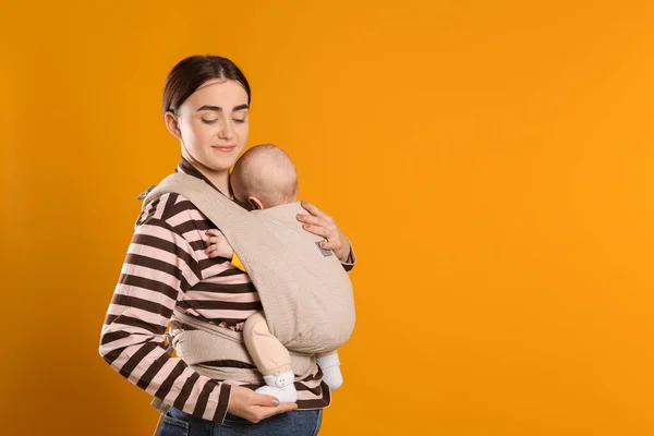 Madre Che Tiene Bambino Fionda Marsupio Sfondo Arancione Spazio Testo — Foto Stock