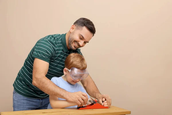 Otec Učí Syna Jak Pracovat Letadlem Béžové Zdi — Stock fotografie