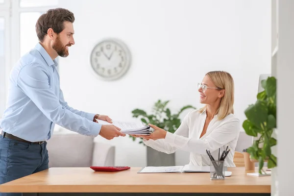 stock image Man giving documents to colleague in office