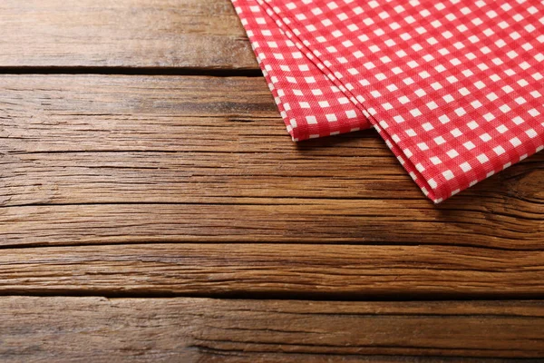 木のテーブルの上の赤いチェックテーブルクロス テキスト用のスペース — ストック写真