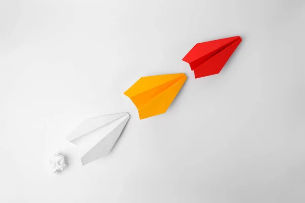 Idea concept. Paper planes following red one on white background, flat lay