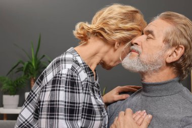 Mutlu, olgun bir çift evdeki kanepede birlikte vakit geçiriyor. Randevu ajansı