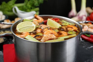 Lezzetli Tom Yum çorbası ve malzemeleri olan tencere, yakın plan.