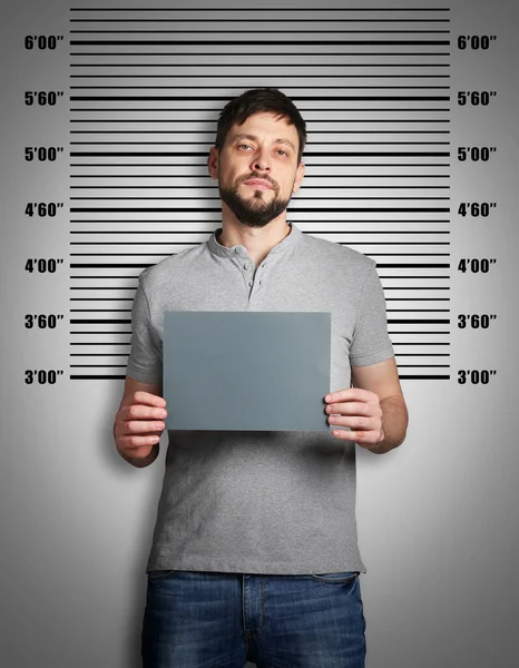 Verbrecherischer Mugshot Mann Mit Blanko Karte Gegen Höhendiagramm Festgenommen — Stockfoto