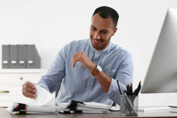 オフィスのテーブルで書類を扱う幸せなビジネスマン — ストック写真